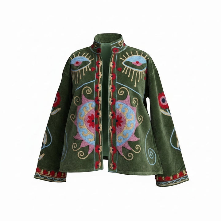 Indigo Haveli green velvet jacket with intricate red and blue Suzani embroidery, featuring eye motifs and floral sun designs.